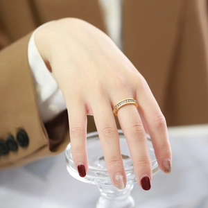 Close-up of elegant gold ring with channel-set white zircons worn on a finger