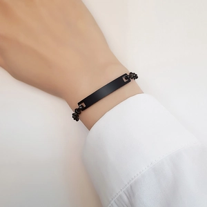 Dettaglio macro di un bracciale a barra rettangolare nero opaco su un polso
