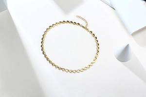 Macro detail of golden heart-shaped link necklace with adjustable extender chain