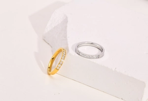 Détail de bagues minimalistes or et argent serties de zircons sur une pierre blanche