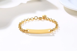 Dettaglio macro di un bracciale in oro acciaio inossidabile con piastra e cuore