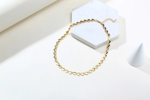 Detailed macro view of 18K gold heart-shaped link necklace with lobster clasp closure