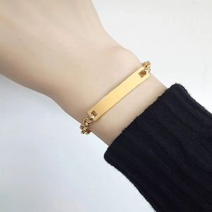 Dettaglio di un bracciale a barra minimalista in acciaio inossidabile dorato
