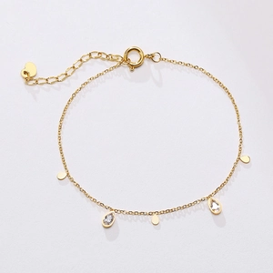 Detail of gold teardrop bracelet with zircon stones and heart charm extension chain