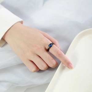 Close-up of black beaded steel ring with heart-shaped blue zircon on hand