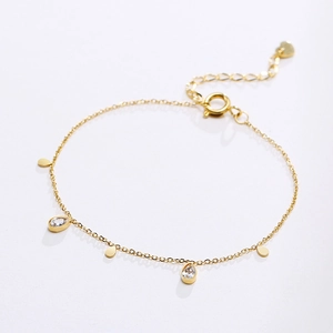 Close-up of gold-plated stainless steel bracelet with teardrop-shaped zircon charms