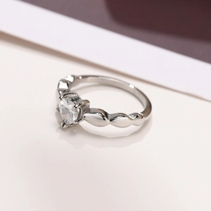 Detailed close-up of heart-shaped zircon ring with unique twisted wave band design