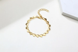 Detailed view of golden heart-shaped link bracelet with lobster clasp and adjustable chain