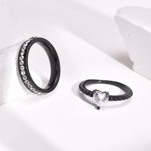 Macro detail of black titanium stackable rings with heart-shaped zircon and pave setting