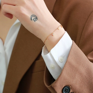 Detailed view of a gold teardrop zircon bracelet on a wrist with minimalist French styling