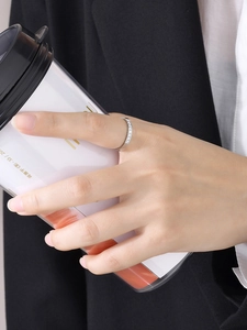 Détail d'une bague minimaliste en argent sertie de zircons cubiques portée par un mannequin