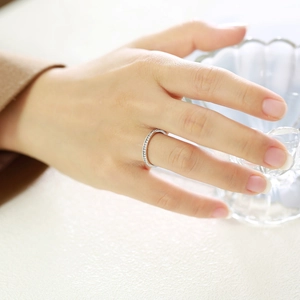 Close-up of a slim silver eternity ring with zircon stones worn on a finger