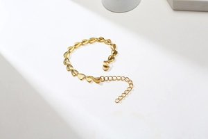 Detailed view of golden leaf-shaped link bracelet with textured finish and lobster clasp