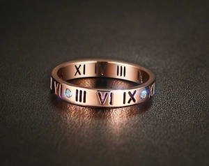 Detailaufnahme des roségoldenen Rings mit römischen Ziffern und Zirkonia-Einlagen