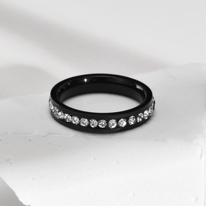 Macro shot of black titanium steel ring with a single row of sparkling white zircons