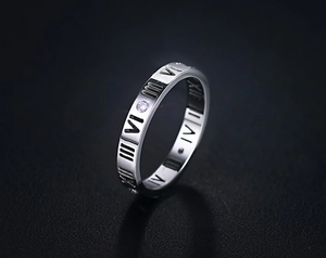 Makroaufnahme des silbernen Römischen Zahlen Rings mit Zirkonia auf schwarzem Leder