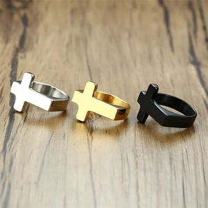 Men's titanium steel cross rings in gold, silver, and black on a wooden background
