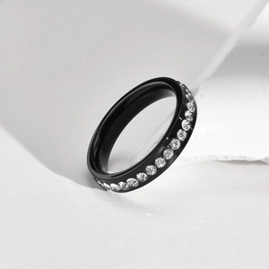 Macro shot of black titanium steel band ring inlaid with a row of round white zircons