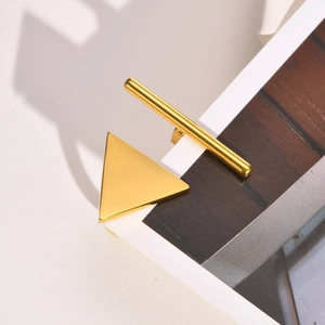 Detailed macro view of a minimalist golden geometric triangle ring on a wooden surface