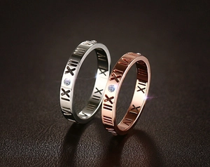 Nahaufnahme von Ringen mit römischen Ziffern in Silber und Roségold mit Zirkon-Inlay