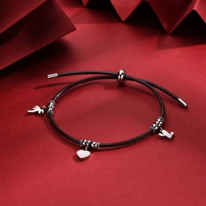 Close-up of adjustable leather bracelet with heart, bird and cactus silver charms