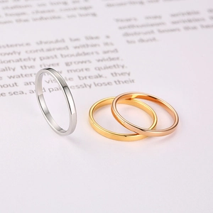 Close-up of minimalist stacked rings in silver, gold, and rose gold polished finishes