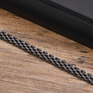 Macro detail of multi-layer black stainless steel mesh chain with industrial woven texture