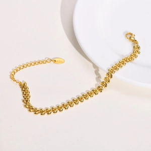 Detail of gold wheat link bracelet featuring lobster clasp and K18 engraved tag