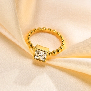 Elegant gold beaded ring with a square-cut sparkling cubic zirconia on peach silk