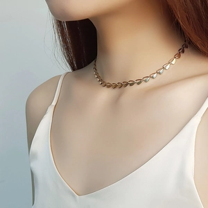 Polished stainless steel leaf necklace in gold finish worn by a model as a choker