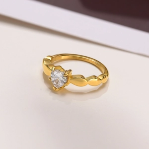 Macro shot of gold heart ring with wave band and sparkling heart-shaped zircon