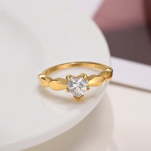 Detailed view of heart-shaped zircon ring with gold plating on a ceramic tray