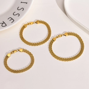 Close-up of triple-layered golden stainless steel mesh bracelets with fold-over clasp detail