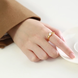 Detailed view of a gold heart-shaped zircon ring on a model hand for a stylish look
