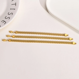 Detailed shot of three gold-plated stainless steel mesh bracelets with lobster clasps