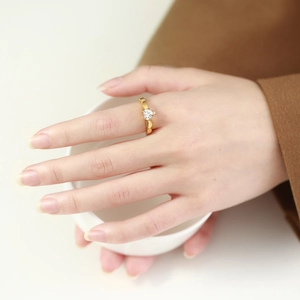 Macro detail of a golden heart-shaped zircon ring with an intricate heart chain band
