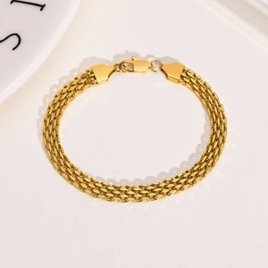 Detailed macro view of a gold triple-layer mesh band bracelet with a lobster clasp