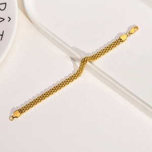 Macro detail of triple-strand golden mesh chain bracelet with shield metal ends and lobster clasp