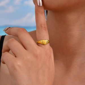 Bague cœur dorée minimaliste pour femme en acier inoxydable poli sur la main du modèle