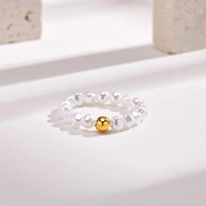 Détail d'une bague en perles irrégulières avec une perle en acier plaqué or 18 carats