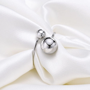 Macro di anello regolabile in argento con due sfere lucide su tessuto di seta bianca