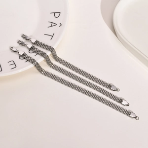Close-up of three parallel silver stainless steel mesh bands with lobster clasp detail