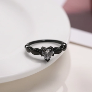 Macro view of heart-shaped zircon ring with black plating and stone setting detail