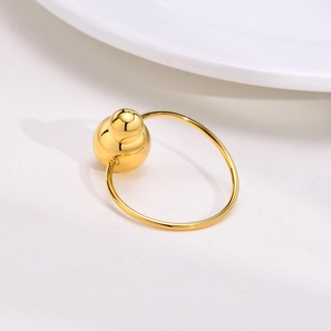 Dettaglio macro di un anello regolabile dorato in acciaio con design a sfere a zucca
