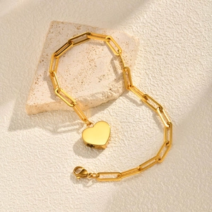 Detail eines 18K vergoldeten Herz-Urnenarmbands aus Edelstahl auf Stein mit scharfen Schatten