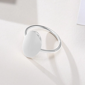 Macro close-up of oval flat polished stainless steel ring with minimalist silver finish