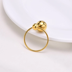 Dettaglio macro dell'anello regolabile in acciaio dorato con design a doppia sfera