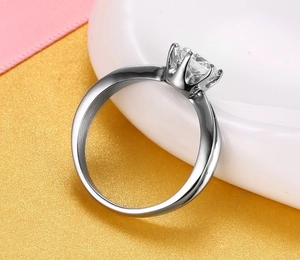 Macro side view of silver crown ring with six-prong set round brilliant gemstone