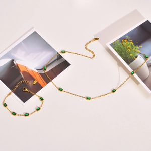 18K gold necklace and bracelet set featuring emerald green zircon gemstones on white