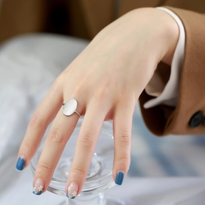 Polished silver stainless steel oval ring for women styled on finger with glass